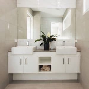 Frameless Mirror above two white basins